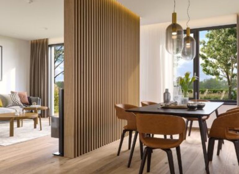 Interior of a family house with a wood-decorated floor, dining table, and living area.
