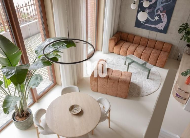 A bright living room with a round table and artificial flooring in a two-room apartment.
