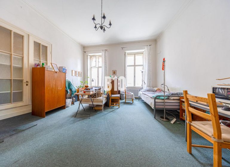 A spacious room with two beds and a carpet in a 2-room apartment.