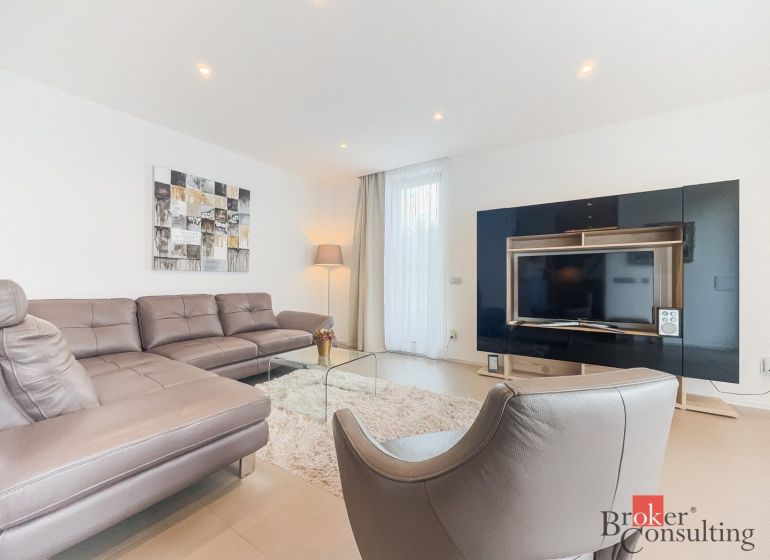 Living room with a black TV cabinet, sofa, and armchair in a two-room apartment.