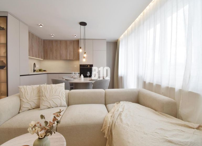 Living room with a kitchenette and a sofa in a 4-room apartment.