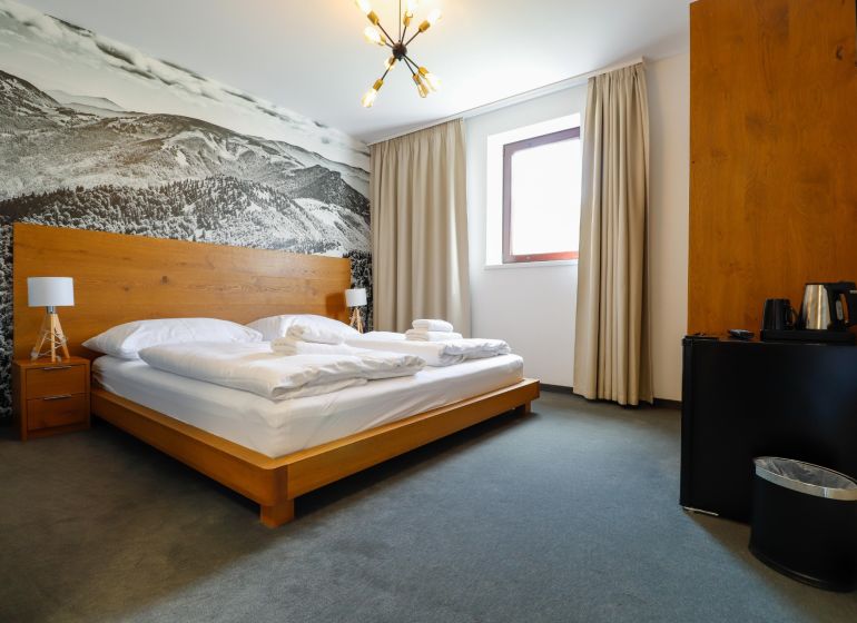 Double room in a Holiday Apartment with a decorative wall and minimalist furnishings.