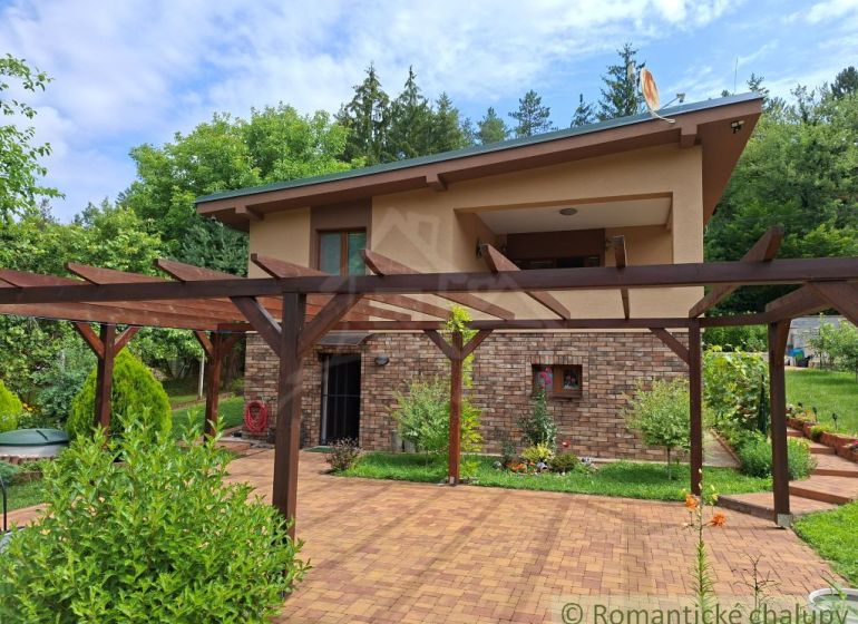 A family house in Veľké Uherce surrounded by a pergola and garden paving.