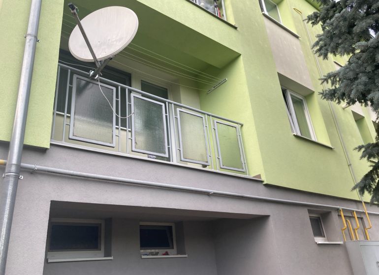 The facade of a 3-room apartment in Volkovce with a balcony and a satellite dish.