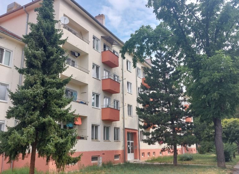 Apartment building with balconies surrounded by greenery on 28th October Street in Trenčín.