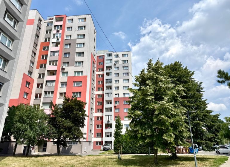 The exterior of the apartment building on Andrusovova Street in Bratislava - Petržalka with landscaped greenery.