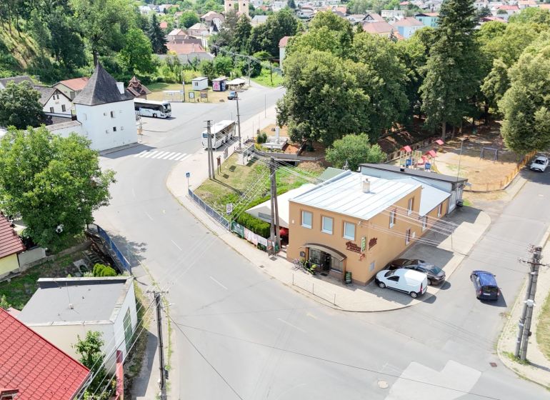 Aerial view of commercial premises in Divín surrounded by greenery and historic buildings.