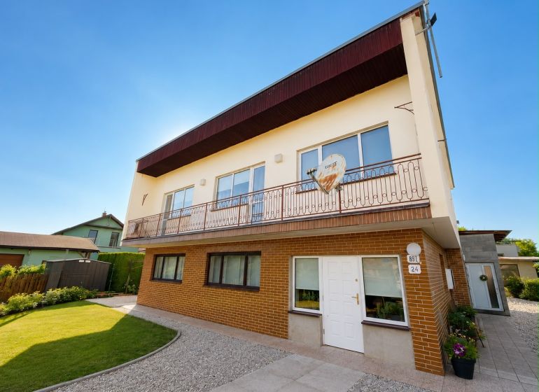 A family house in Bytča with a garden, two floors, brick facade, and a balcony.