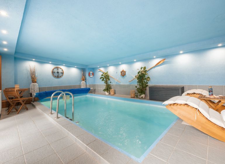 An indoor swimming pool in a family house with nautical-themed decorations.