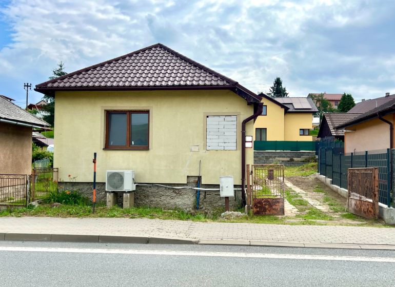 A family house in the village of Ľubotín with a gable roof and a fenced yard.