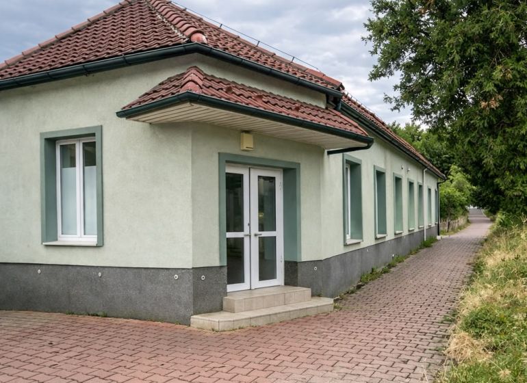 Single-story production facilities in Diakovce with a red tile roof and paved flooring.