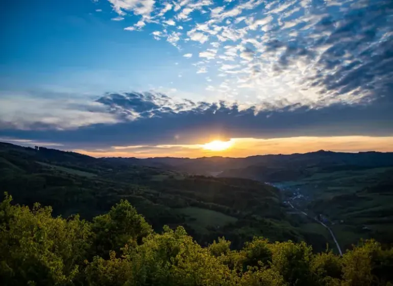 Sunset over agricultural and forest lands near Dohňany with dramatic clouds.