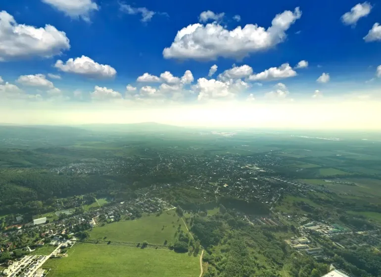 Aerial view of agricultural and forest land in Stupava under a clear sky.