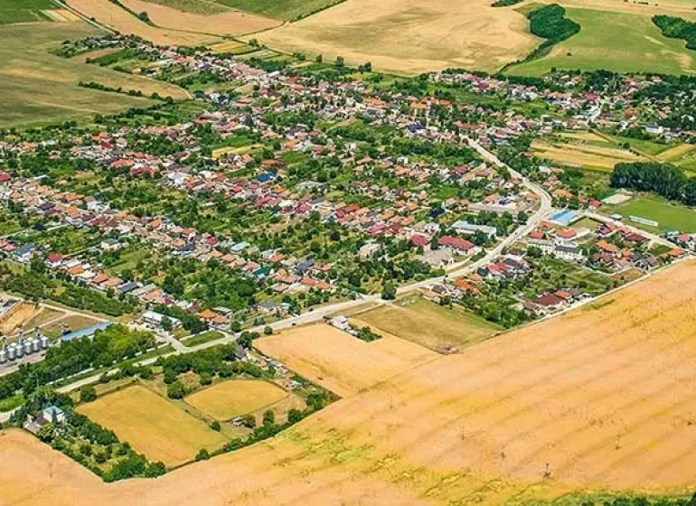 Aerial view of the landscape and gardens in the village of Dvorníky - Včeláre, surrounded by fields.
