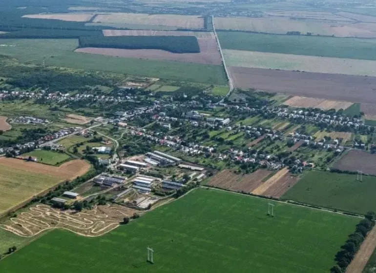 Aerial view of Trhovište with agricultural and forest lands surrounding the village.