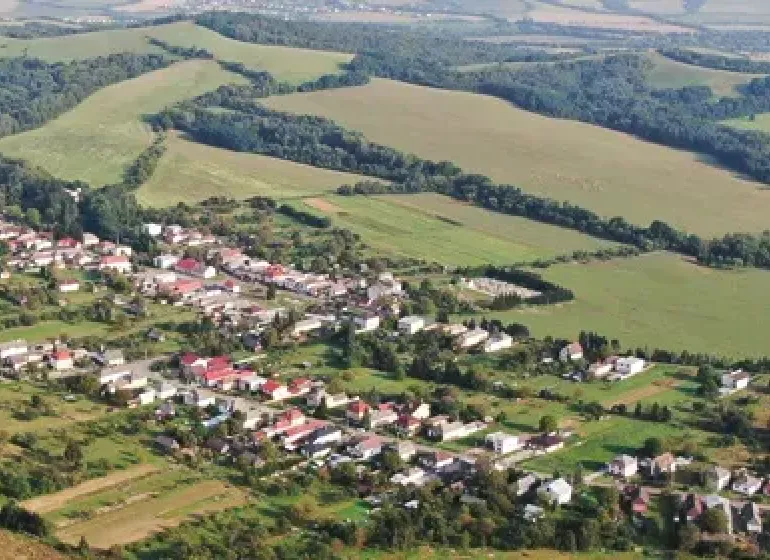An aerial view of Rovné surrounded by agricultural and forest lands.