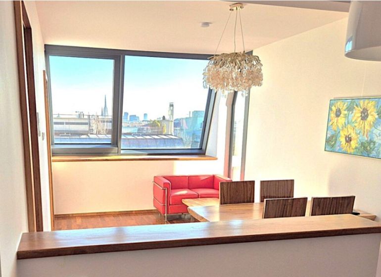 Dining area in a 2-room apartment with a view and wooden decor flooring.