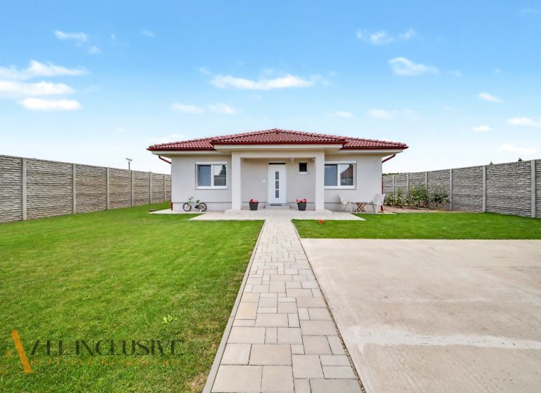 A family house in Vozokany with a lawn, terrace, and a bicycle in front of the entrance.
