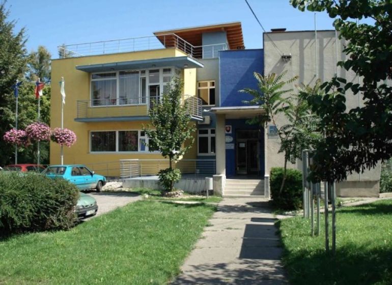 A building in Dunajská Lužná with a green plot and a colorful facade.