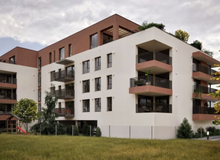 The building on Brigádnicka Street in Piešťany with balconies and greenery, suitable for a 3-room apartment.