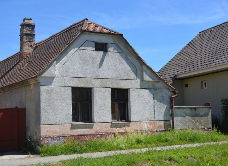 A family house in Lakšárska Nová Ves with visible cracks and an old roof.