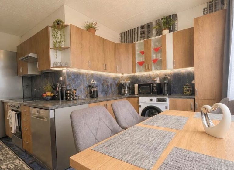 Kitchen in a 2-room apartment with furnishings, wooden decor, and modern lighting.