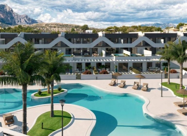 Residential building in Costa Blanca with a pool and palm trees, suitable for a 3-bedroom apartment.