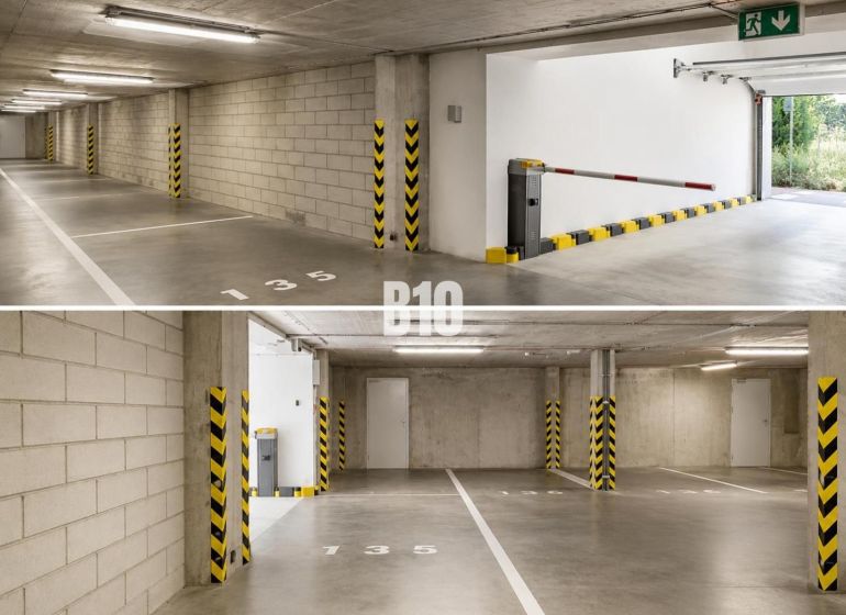 Underground parking in garages with numbered spaces and a barrier.