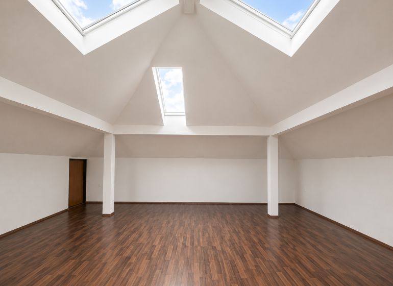 Spacious offices with wood-patterned flooring and skylights.