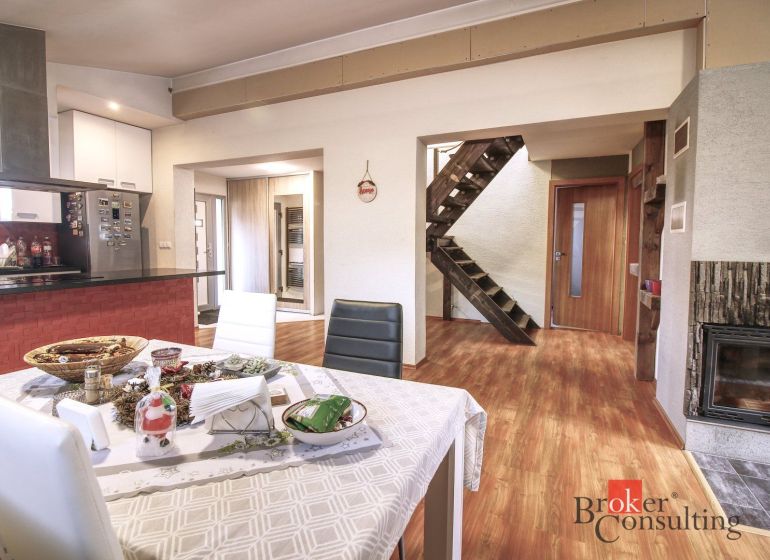 Interior of a family house with a dining room, fireplace, and floor with wooden decor.