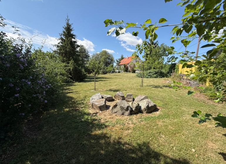 The garden of a family house in Čaradice surrounded by greenery and trees.