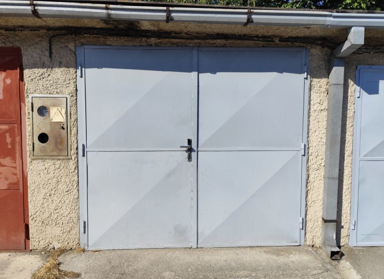 Garages in Nové Zámky with a solid metal entrance and plastered wall.