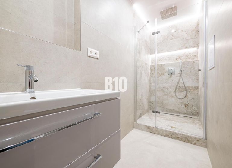 A bathroom in a 3-room apartment with a modern shower and sink.