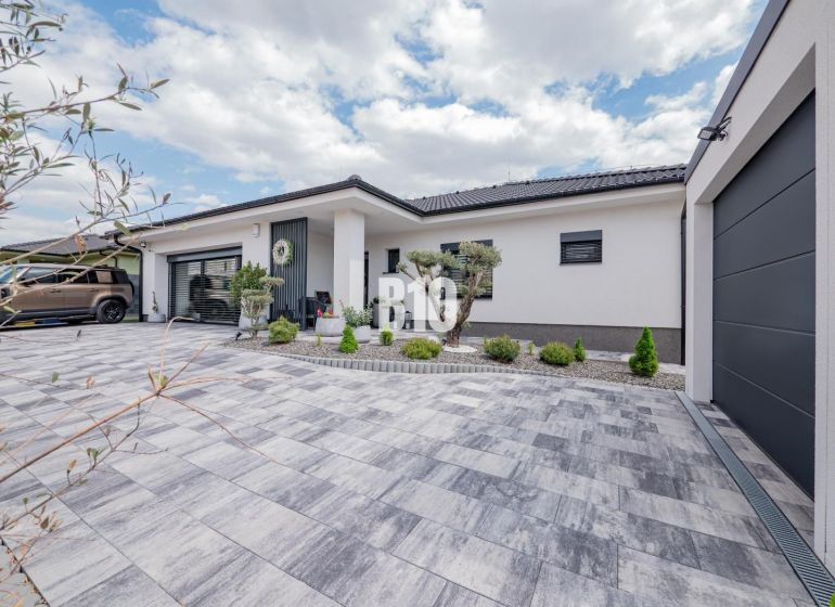 A family house in Nitra with a terraced paved area and a landscaped front garden.