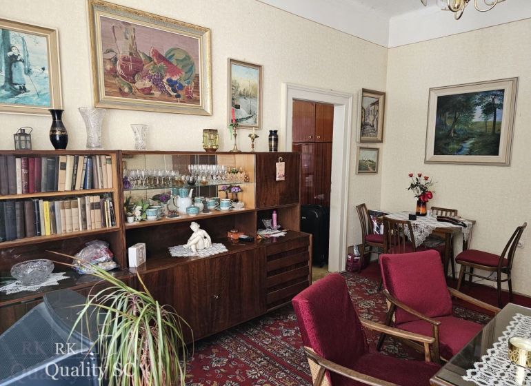 Living room in a two-room apartment, with wooden decorations and red furniture.