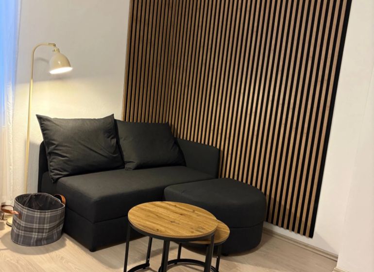 1-bedroom apartment with a sofa, coffee table, and a wall with wooden slats.