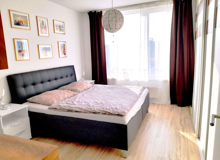 Bright bedroom with wood-decor flooring and decorative paintings, 3-room apartment.