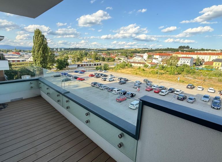A balcony with a wooden decor floor offers a view of Zvolen, Kubániho Street.