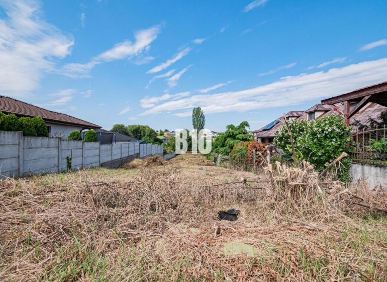 Plots - housing in Nitra, bordered by a fence, with a view of the blue sky.