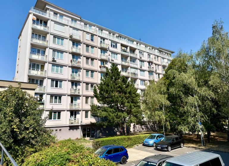 Apartment building on Piešťanská Street in Bratislava - Nové Mesto surrounded by greenery and a parking lot.