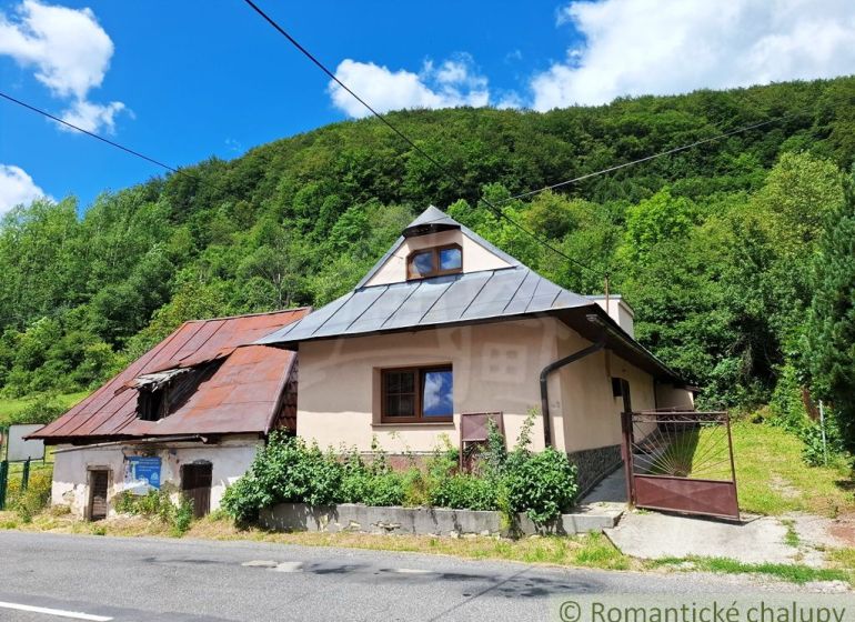 An old house with a sloped roof in Mýto pod Ďumbierom, surrounded by greenery.
