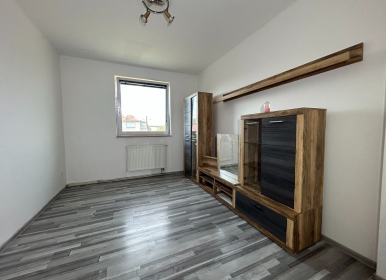 Living room in a 2-room apartment with a wooden decor floor and furniture.
