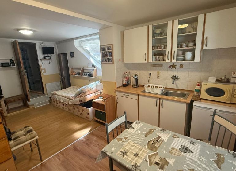 Kitchen corner with cabinets, table, and sofa, wooden decor flooring in a family house.