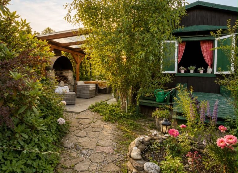 A garden by the cottage in Žilina with stone paths and a flower bed.