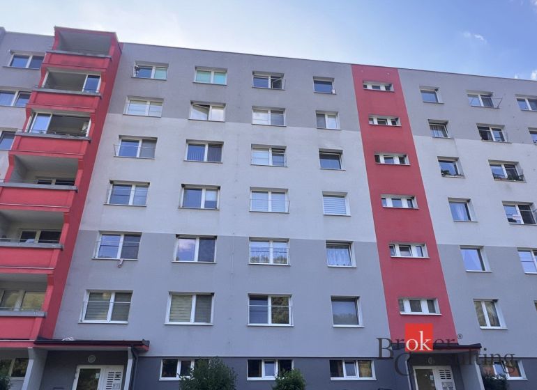 A six-story apartment building in Utekáč with balconies and colored sections of the facade.