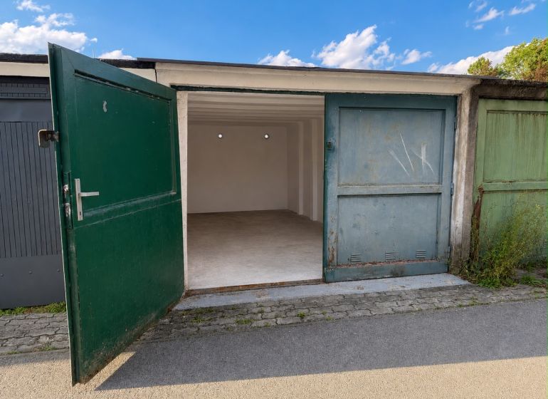 Open garage on Komenského Street in Žilina with a green gate.