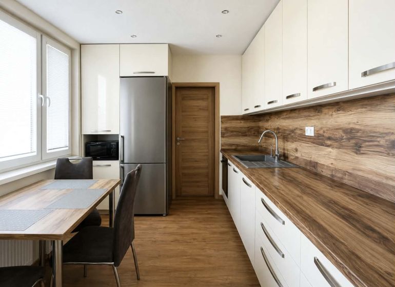 A kitchen in a 3-room apartment with a floor and countertop featuring a wood design.