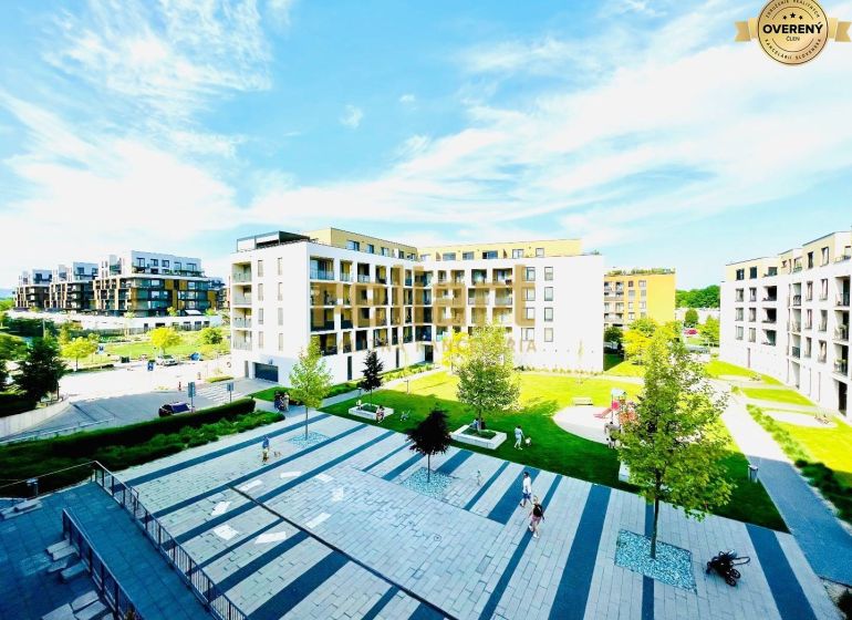 A seat with modern buildings and greenery in Bratislava-Petržalka on Žltá Street.