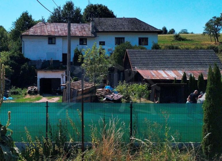 A family house in Stará Turá with a garden, fencing, and extensions, with a view of the countryside.
