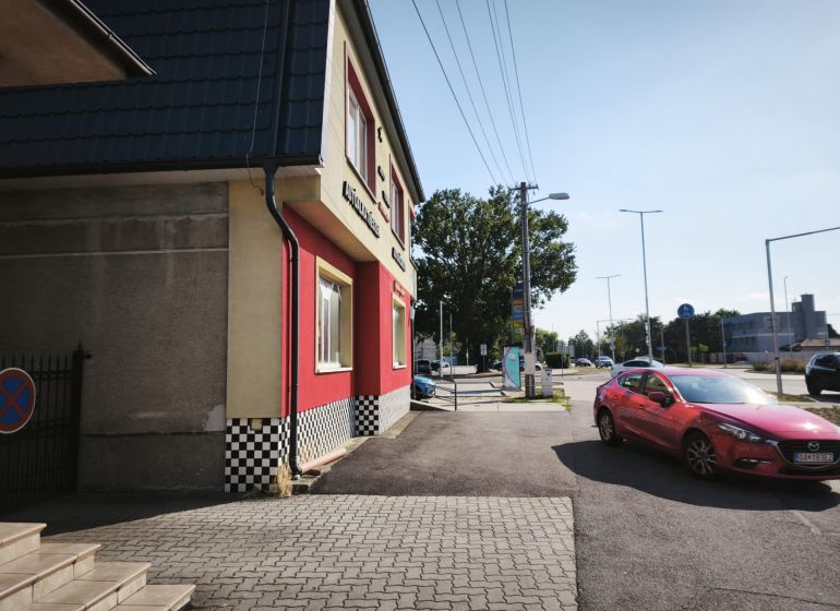 Commercial premises on SNP Street in Šaľa with a red car on the road.